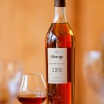 Bouteille d'Armagnac Darroze de la Collection Unique, domaine de Bellevue, millésime 2000 avec un verre de dégustation.