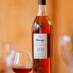 Bouteille d'Armagnac Darroze de la Collection Unique millésime 2010 avec un verre de dégustation.