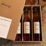 Coffret Les Flacons Darroze Collection Unique millésimes 2006, 1996 et 1986 posé sur du bois vue de haut.